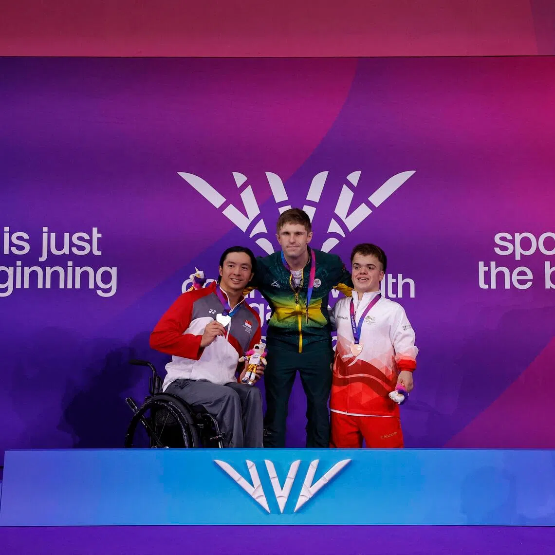 Singapore’s Toh Wei Soong celebrating his 50m freestyle S7 silver medal with winner Christian Sadie of South Africa and England’s bronze medallist Bruce Dee on the podium at the Tollcross International Swimming Centre in Glasgow on July 29.