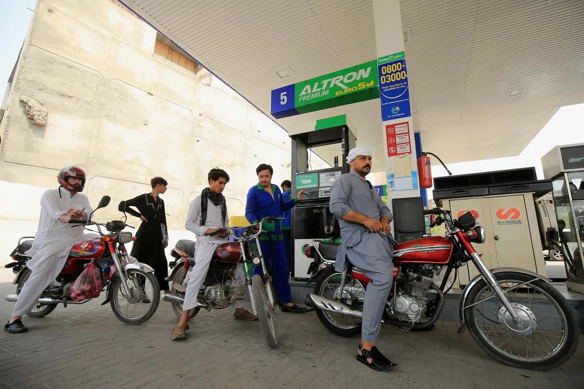 A gas station attendant fills a motorcycle in Peshawar, Pakistan, on May 27, 2022. 