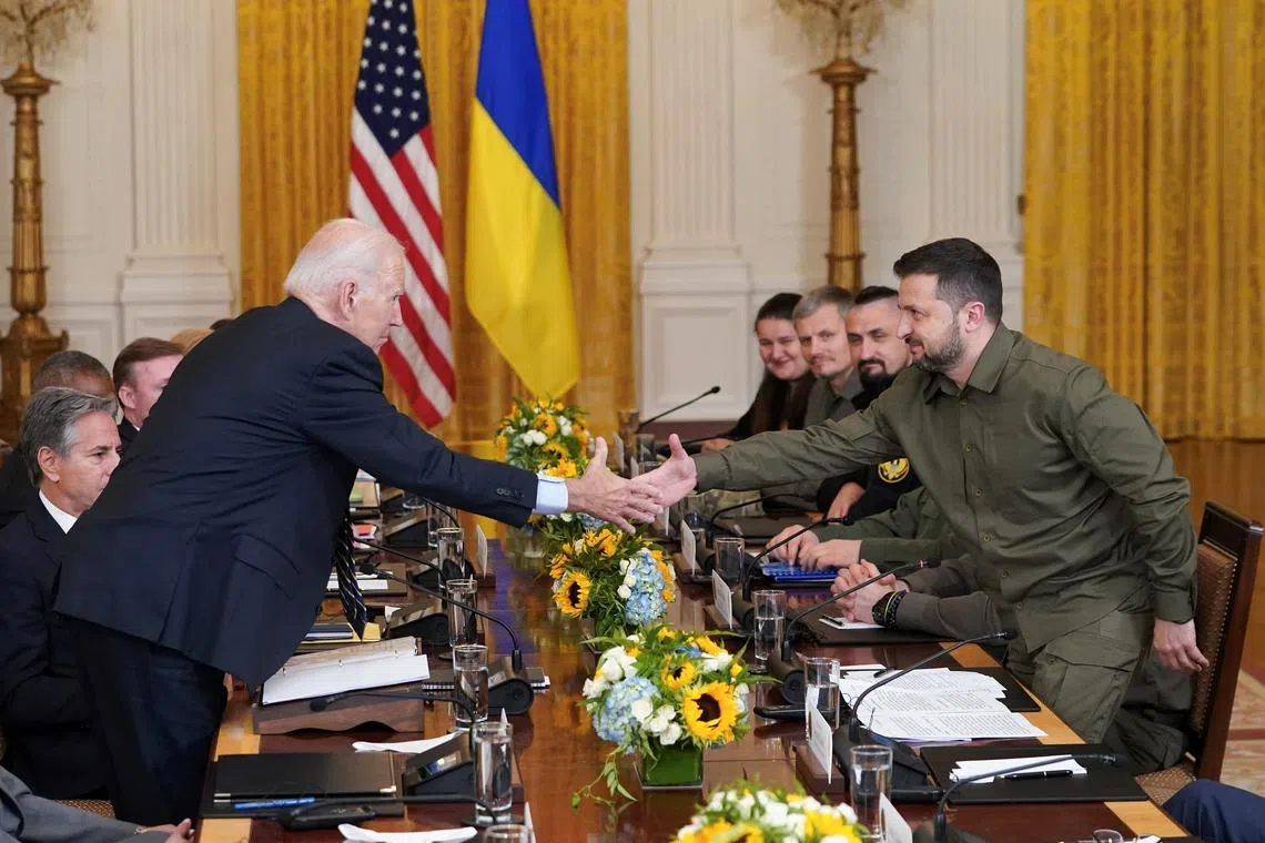 FILE PHOTO: U.S. President Joe Biden and Ukraine President Volodymyr Zelenskiy shake hands across the table during a meeting in the East Room of the White House in Washington, U.S. September 21, 2023. REUTERS/Kevin Lamarque/File Photo