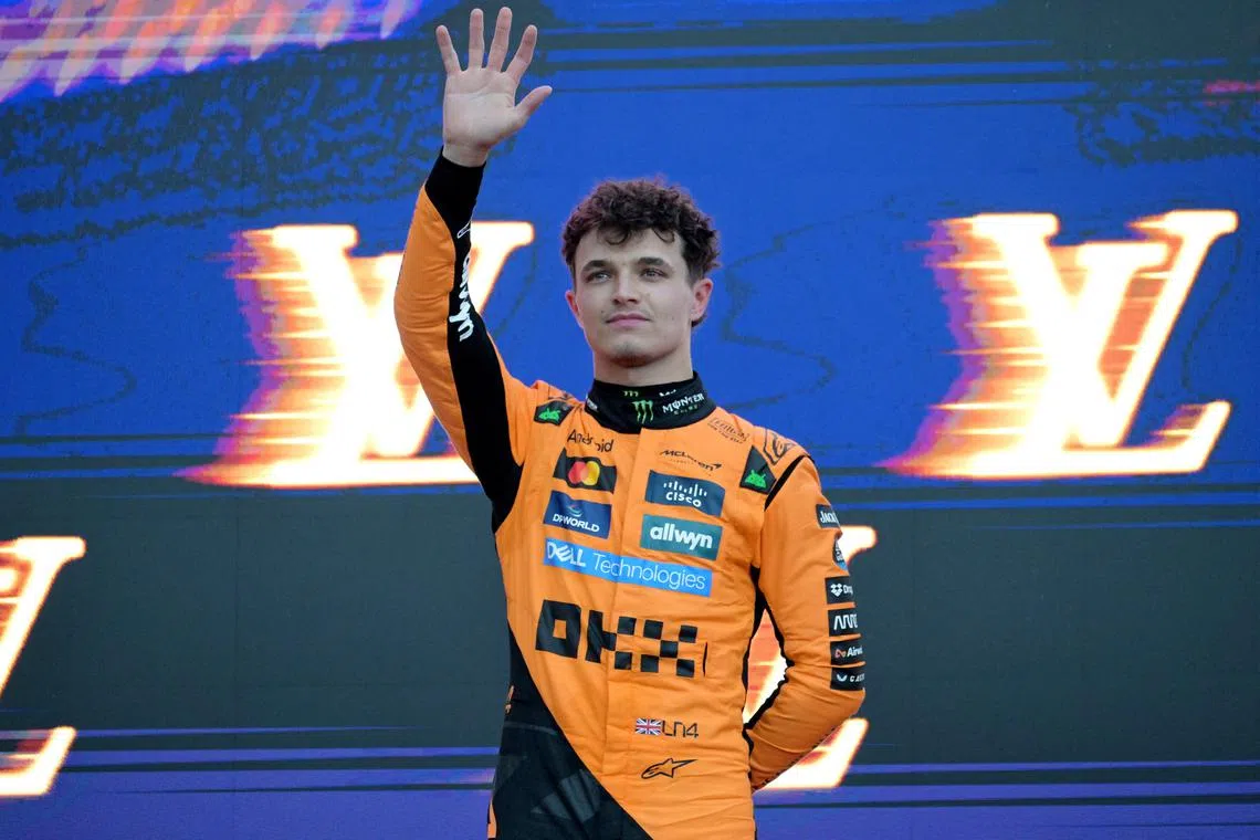 FILE PHOTO: Formula One F1 - Australian Grand Prix - Albert Park Grand Prix Circuit, Melbourne, Australia - March 16, 2025 McLaren's Lando Norris celebrates with the trophy on the podium after winning the Australian Grand Prix along with second placed Red Bull's Max Verstappen and third placed Mercedes' George Russell REUTERS/Tracey Nearmy/File Photo