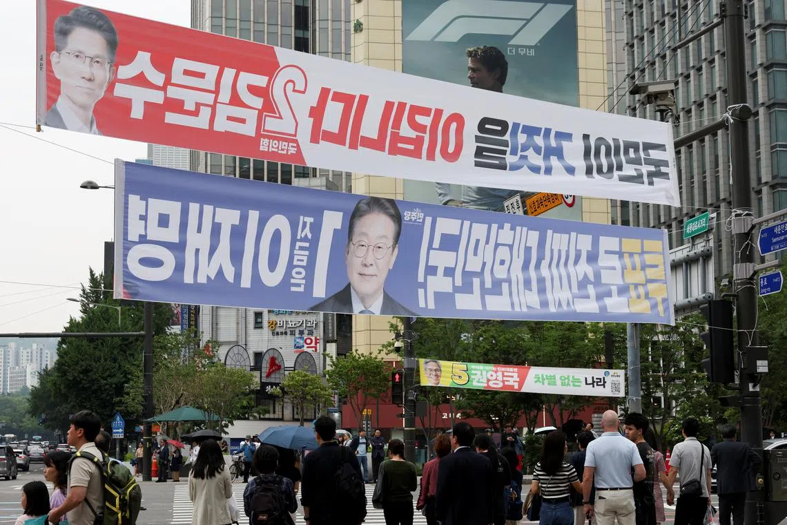 Presidential candidates' campaign banners are raised as people wait for street signal ahead of the presidential election in Seoul on June 2.