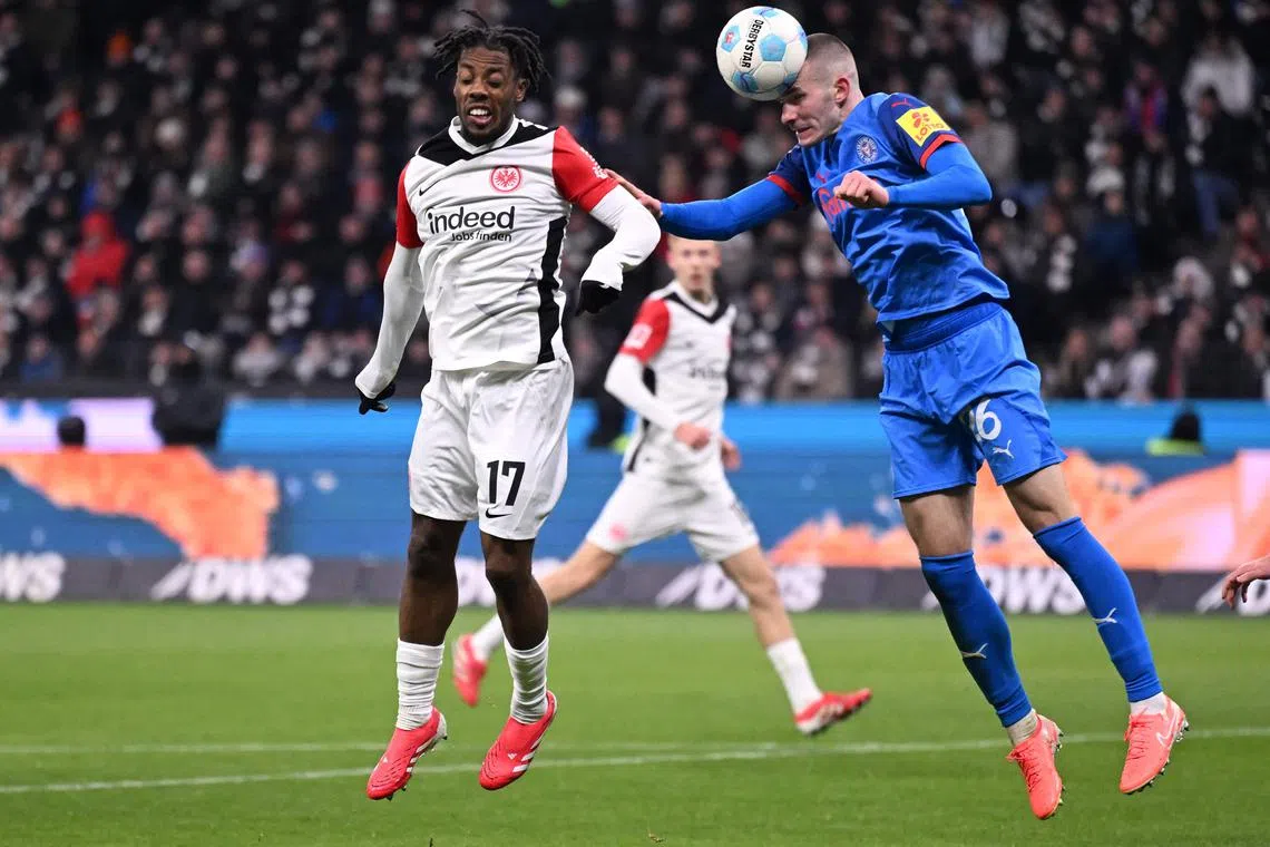 Frankfurt's French forward Elye Wahi and Holstein Kiel's Slovenian defender David Zec vie for the ball during their Bundesliga match in Frankfurt on Feb 16, 2025.