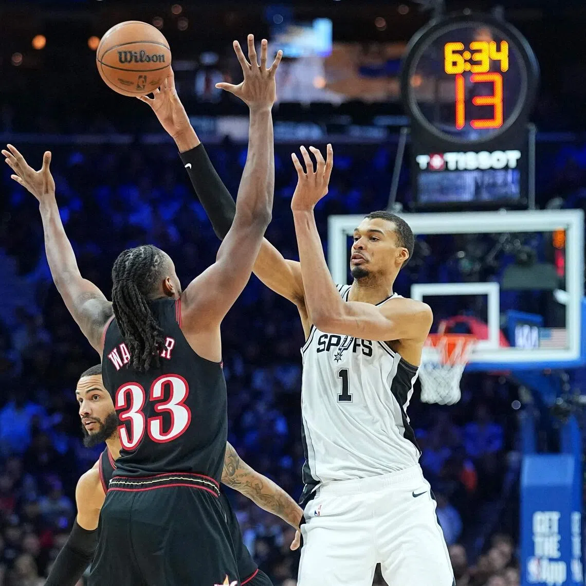 Victor Wembanyama of the San Antonio Spurs passes the ball against Jabari Walker of the Philadelphia 76ers in the third quarter at Xfinity Mobile Arena.