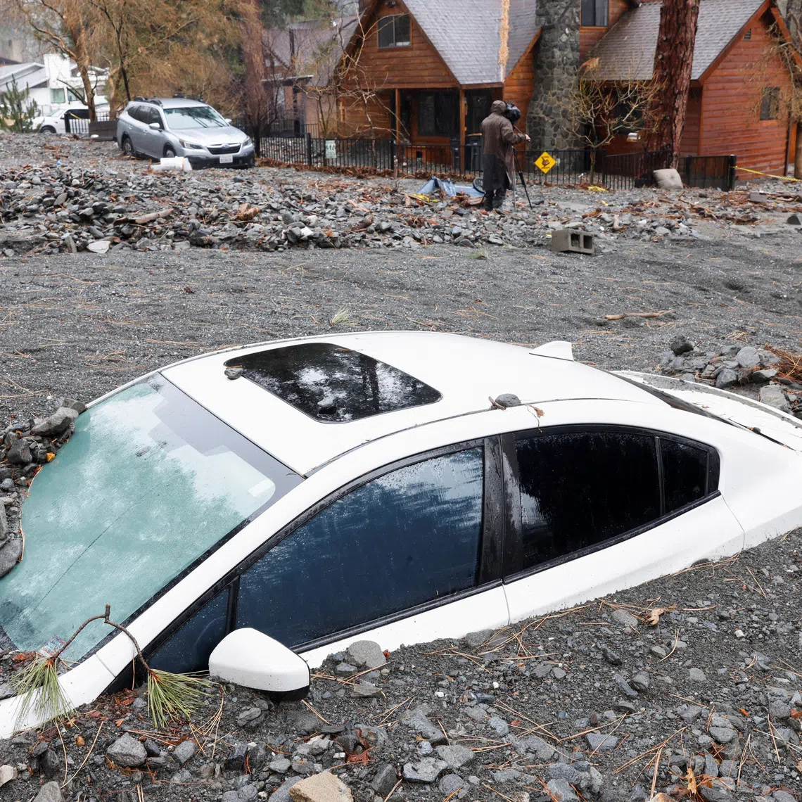 A car lies partially buried, as heavy rains fall due to an atmospheric river, in Wrightwood, California, U.S., December 26, 2025. REUTERS/Jill Connelly