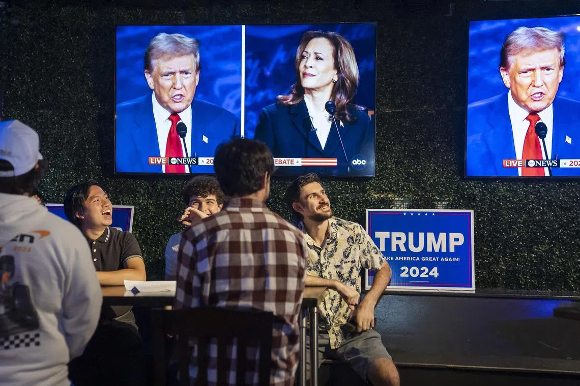 Patrons watch the presidential debate between Former President Donald Trump and Vice-President Kamala Harris, on television screens at The Ivy in Atlanta on Sept 10, 2024. 
