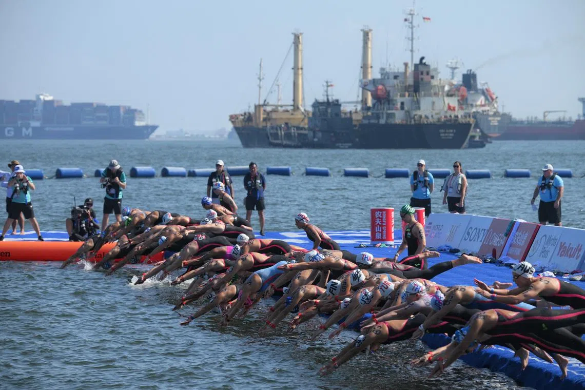 Competitors jumping in at the start of the women's open water swimming competition in Sentosa on July 16.