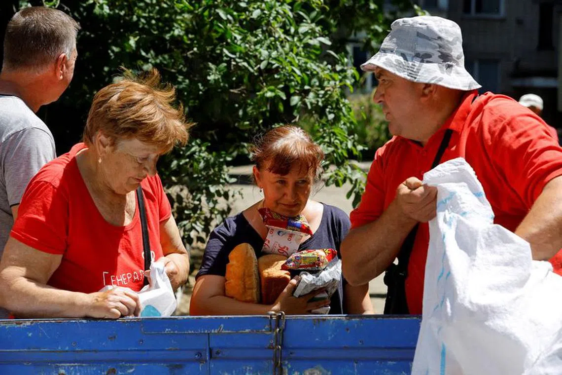 FILE PHOTO: Local residents receive water and food aid after floodwaters receded following the collapse of the Nova Kakhovka dam in the course of Russia-Ukraine conflict, in the town of Hola Prystan in the Kherson region, Russian-controlled Ukraine, June 17, 2023. REUTERS/Alexander Ermochenko/File Photo