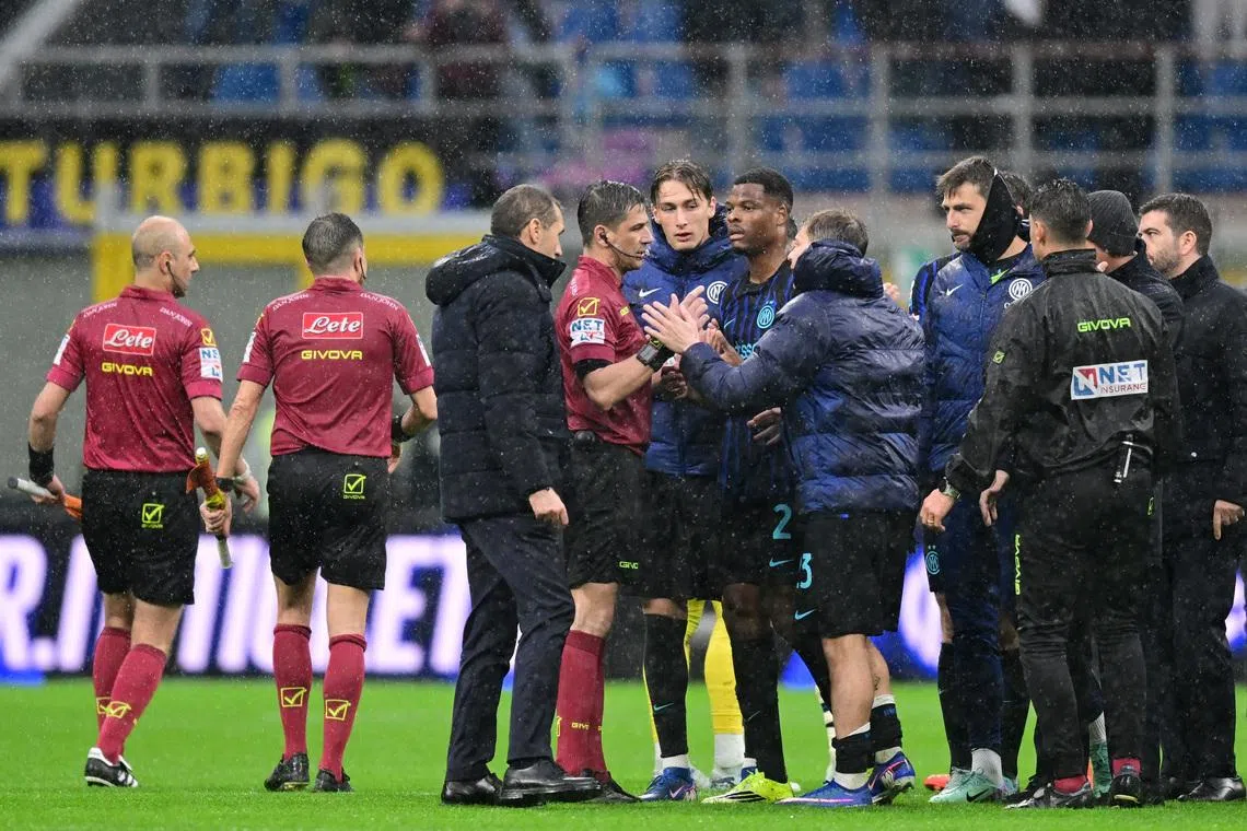 Soccer Football - Serie A - Inter Milan v Atalanta - San Siro, Milan, Italy - March 14, 2026 Inter Milan's Denzel Dumfries and Nicolo Barella with referee Gianluca Manganiello after the match REUTERS/Daniele Mascolo