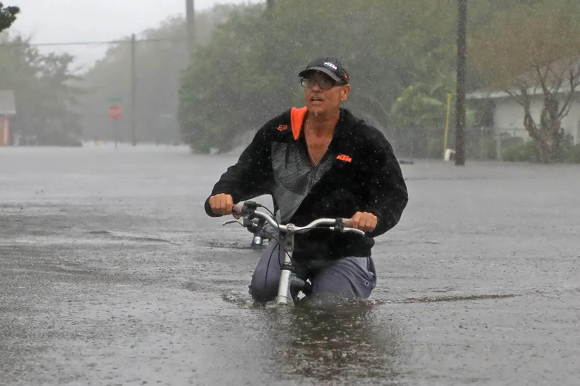 A resident on Magnolia Avenue surveys the flooding damage after Hurricane Milton passed in South Daytona, Florida, U.S. October 11, 2024.  Nadia Zomorodian/News-Journal/USA Today Network via REUTERS
