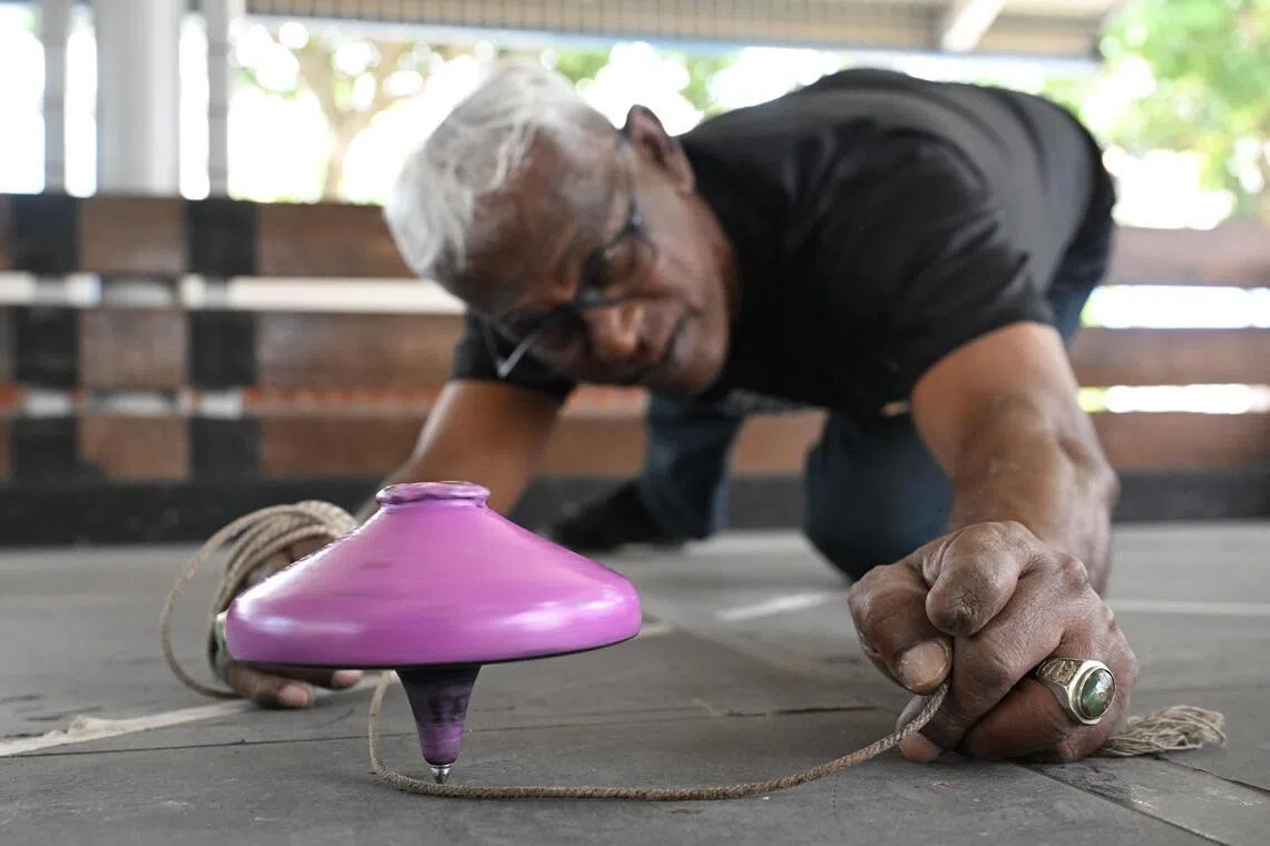 Noorul Hayath adjusting his gasing as it spins during a game at the Kolam Ayer Gasing & Games Court on Jan 5, 2026.