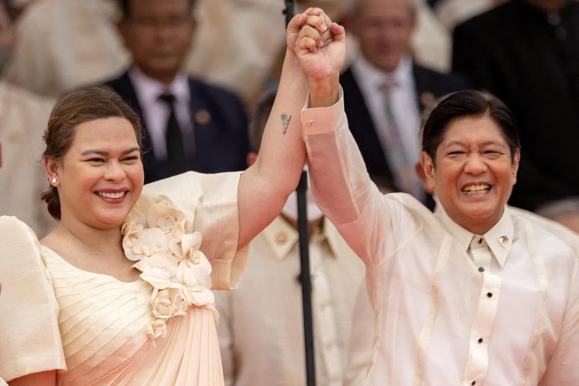 Vice-President Sara Duterte raises the arm of President Ferdinand Marcos Jr during the inauguration ceremony at the National Museum in Manila, Philippines, June 30, 2022. 