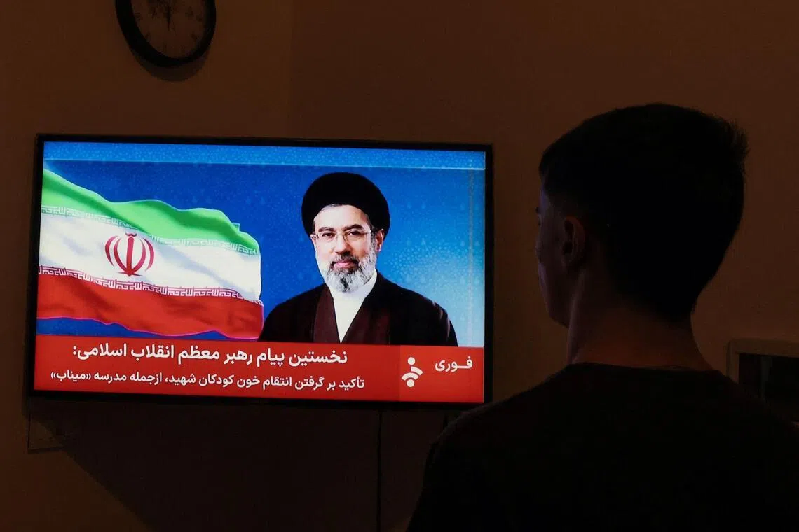 A man watches a televised statement by Iran's new supreme leader Mojtaba Khamenei on March 12, 2026. 