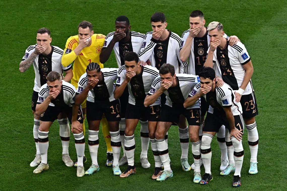 Germany players covering their mouth as they pose for a group picture before the start of the World Cup Group E match against Japan at the Khalifa International Stadium on Nov 23.