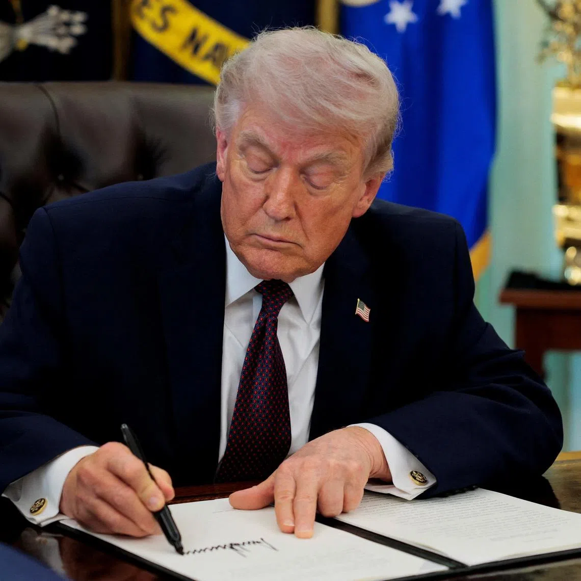 U.S. President Donald Trump signs an executive order on mail ballots, in the Oval Office of the White House in Washington, D.C., March 31, 2026.  REUTERS/Evan Vucci
