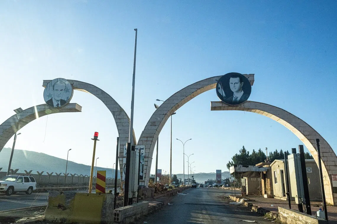 Plaques depicting ousted Syrian President Bashar al-Assad (right) and his late father Hafez al-Assad at an abandoned border checkpoint in Masnaa, Syria, on Dec 9.