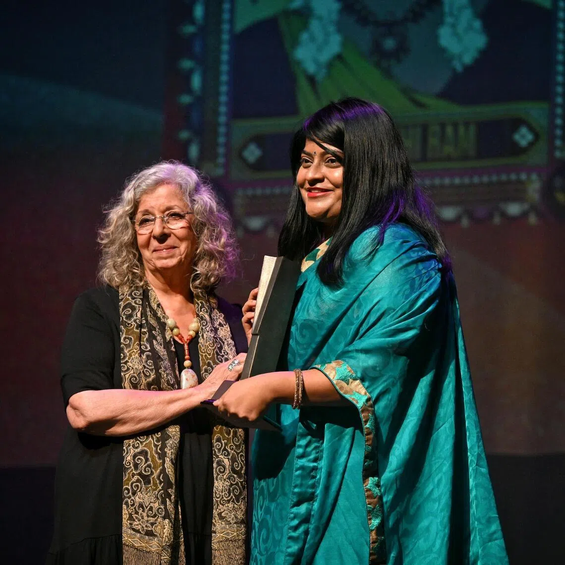 Prasanthi Ram receiving her award from Meira Chand at the Singapore Literature Prize ceremony in 2024.