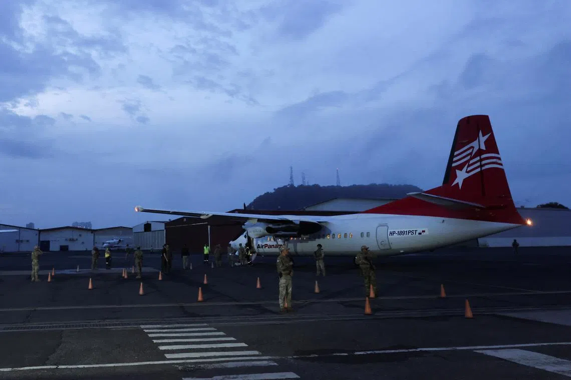 FILE PHOTO: Members of the National Border Service (SENAFRONT) keep watch as Colombian migrants, who were detained after crossing into Panama irregularly through the dangerous Darien Gap, wait to depart after boarding the first U.S. funded repatriation flight, at Tocumen International Airport, in Panama City, Panama August 20, 2024. REUTERS/Aris Martinez/File Photo