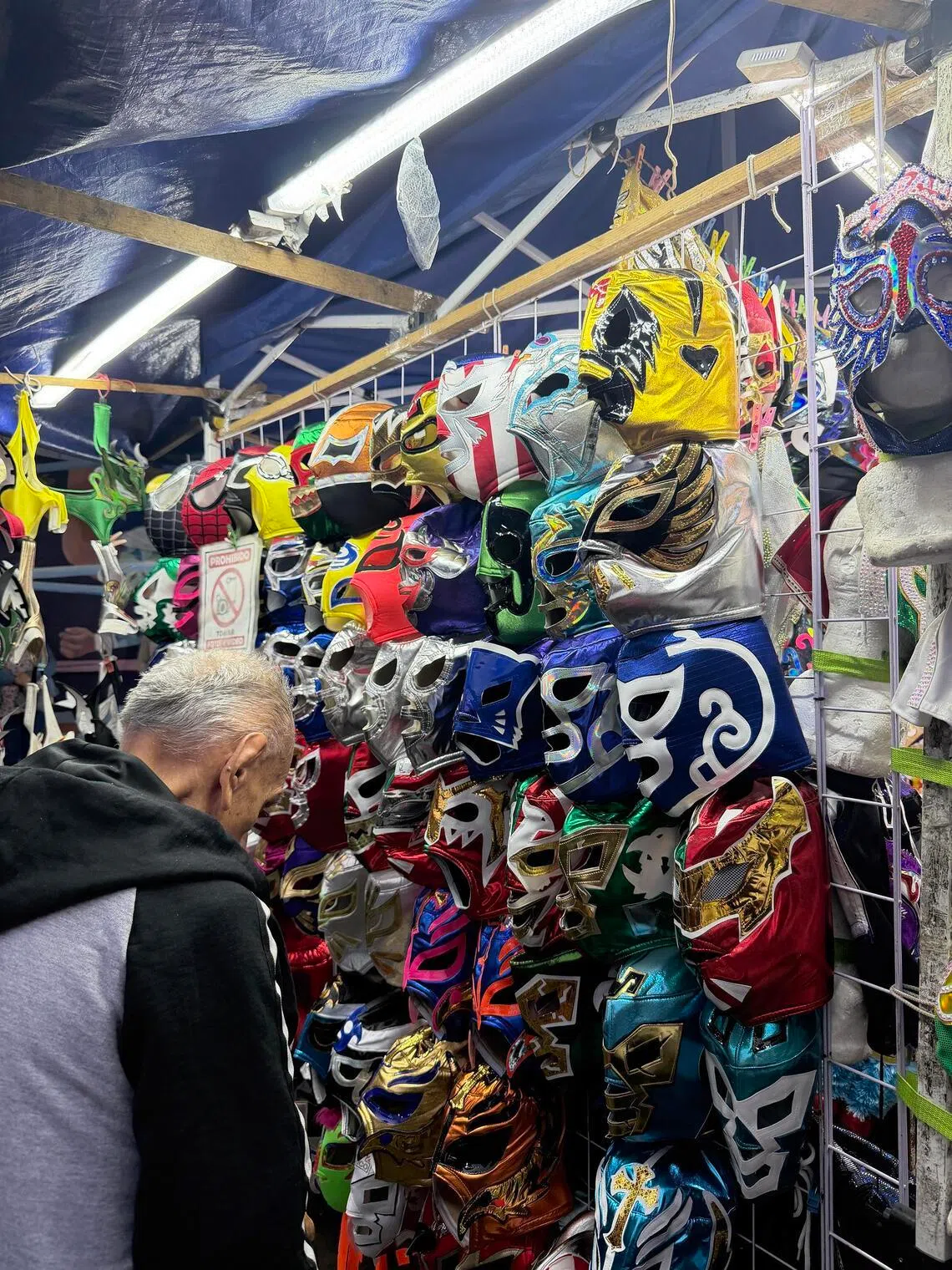 The streets outside Arena Mexico are buzzing with activity with shops such as this selling colourful masks.