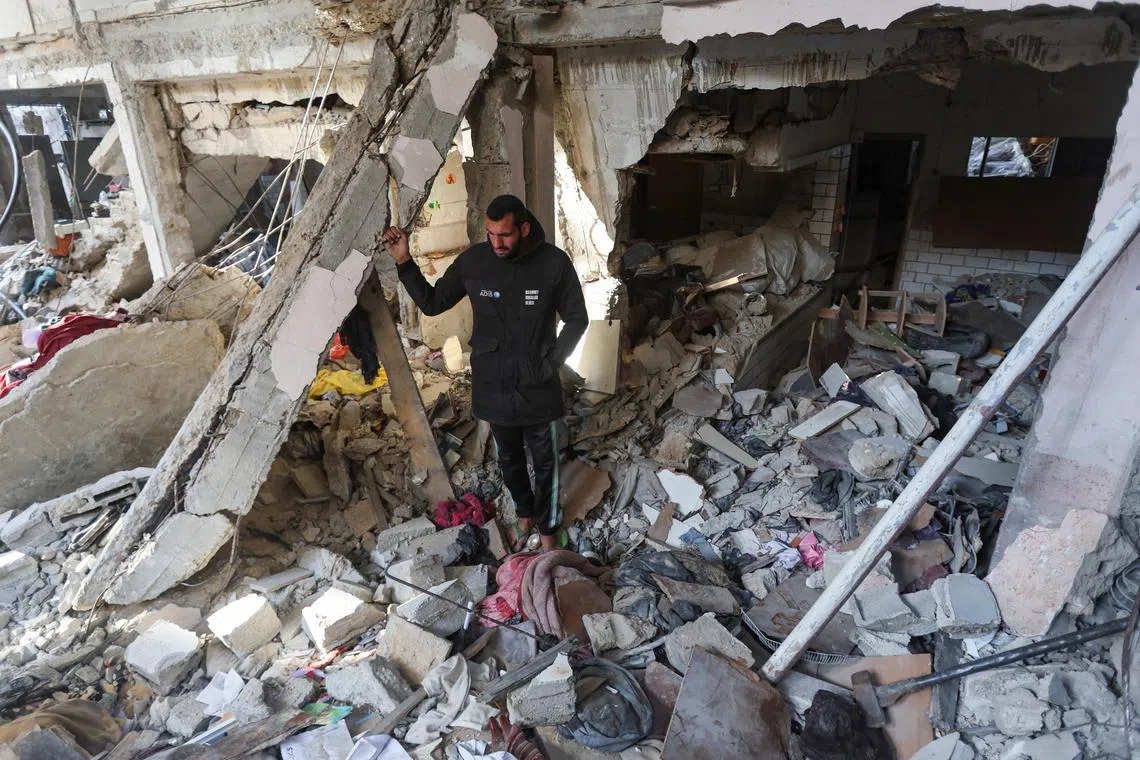 A Palestinian man inspects the site of an Israeli strike on a house, in Bureij in the central Gaza Strip, March 25, 2025. REUTERS/Ramadan Abed