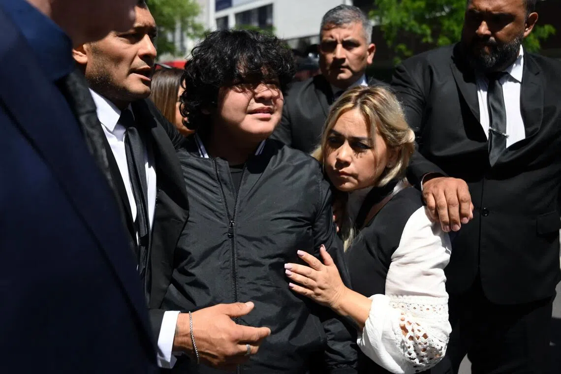 Veronica Ojeda (second from right), ex-partner of late Argentine football legend Diego Maradona, and their son Diego Maradona Ojeda (second from left), are escorted in Buenos Aires on Nov 18, 2025, after a hearing. The trial over his death is now in its third month and entering its final stages.