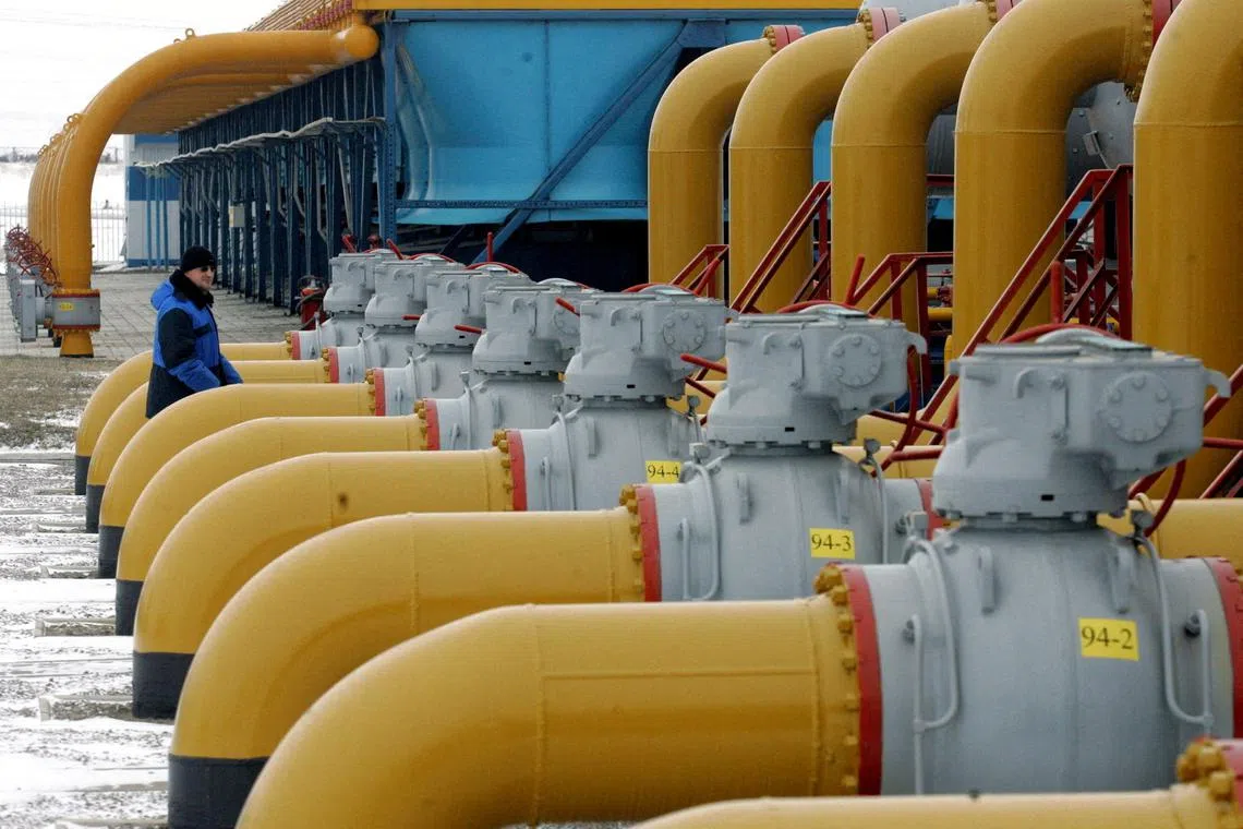 FILE PHOTO: A gas worker walks between pipes in a compressor and distribution station of the Urengoy-Pomary-Uzhgorod gas pipeline, some 30 km (19 miles) from the south western Russian city of Kursk January 4, 2006. REUTERS/Sergei Karpukhin/File Photo