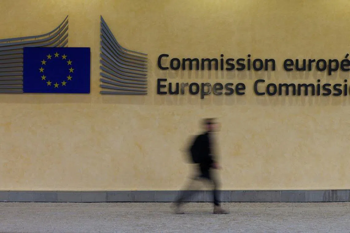 FILE PHOTO: A person walks by the logo of the European Commission near its entrance in Brussels, Belgium, February 1, 2023. REUTERS/Yves Herman