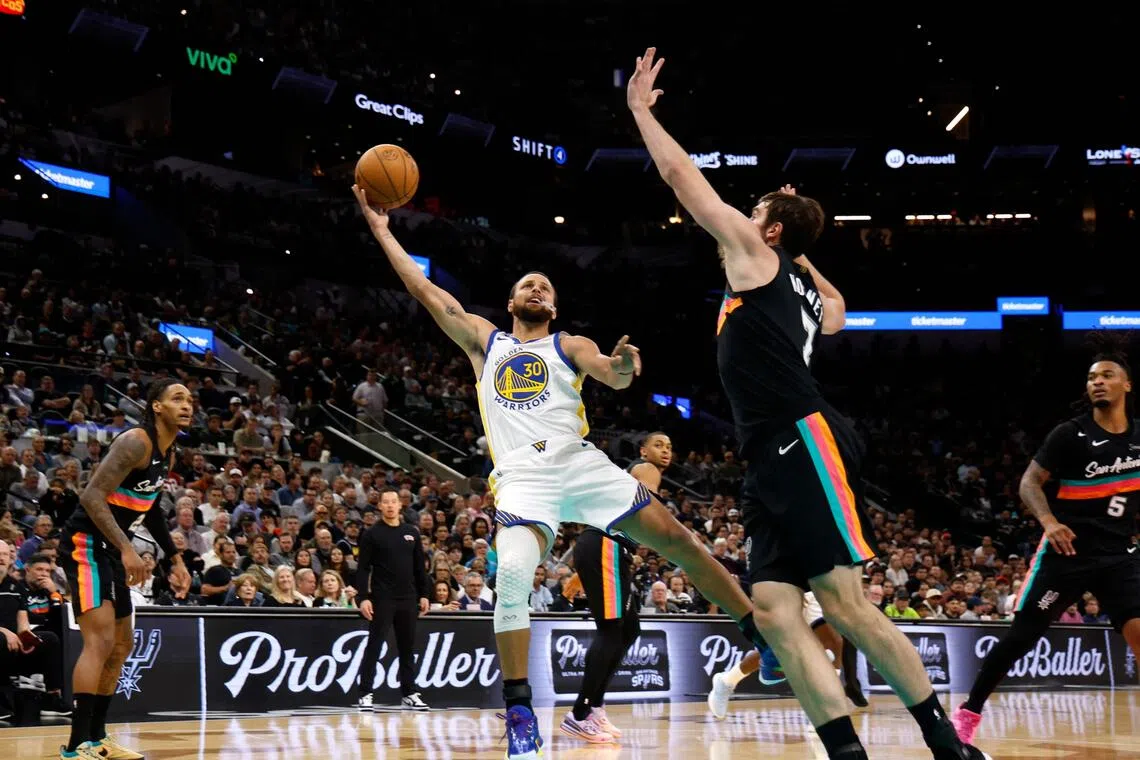 Stephen Curry of the Golden State Warriors shoots against Luke Kornet of the San Antonio Spurs in the second half at Frost Bank Center.