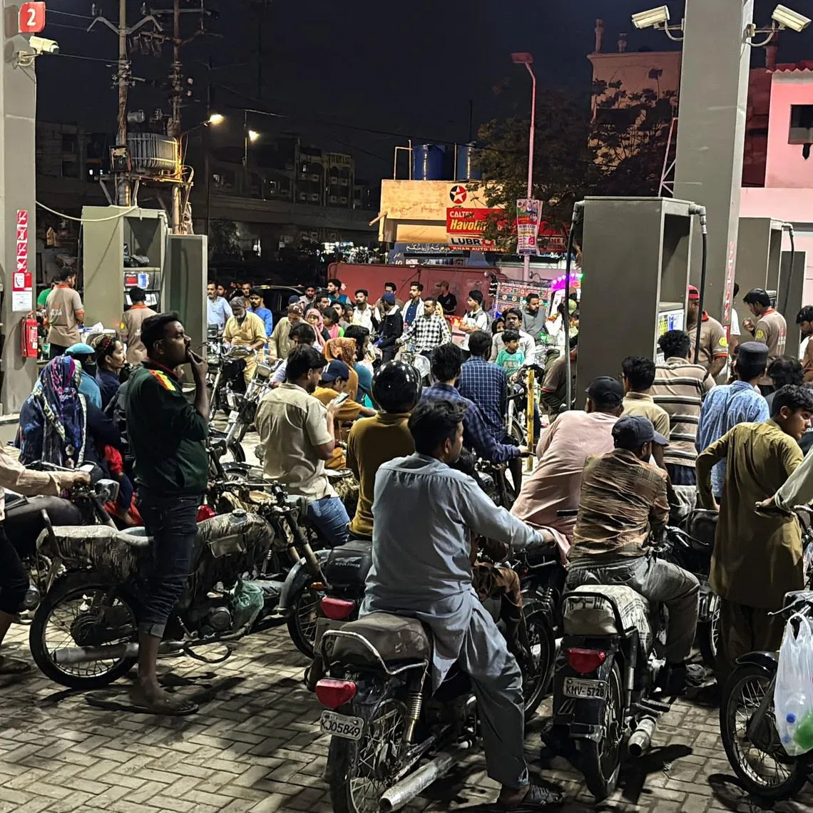 People on their vehicles wait for their turn to get fuel at a petrol station, as fuel prices in Pakistan rise, amid the U.S.-Israeli conflict with Iran, in Karachi, Pakistan, April 2, 2026. REUTERS/Waseem Sattar/File Photo