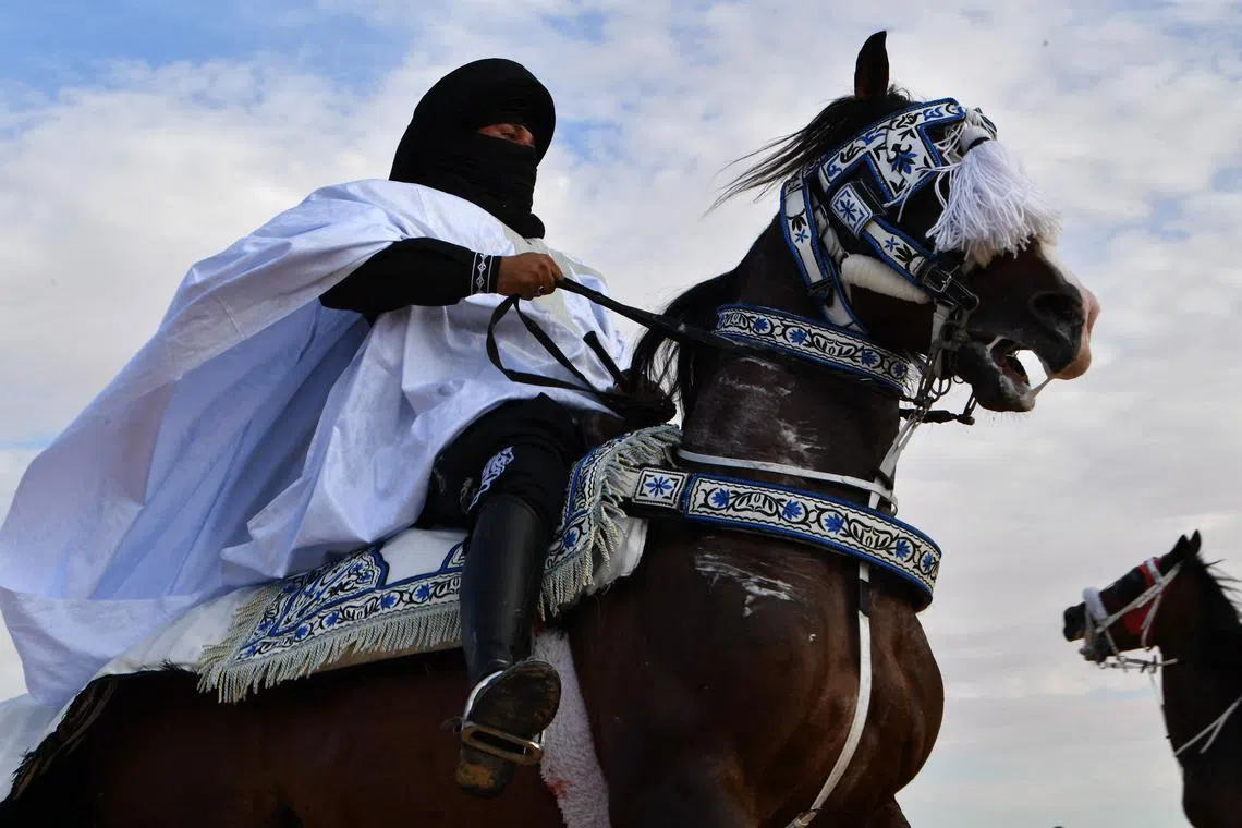 A performer wearing a traditional outfit riding a horse during a show at the start of the International Sahara Festival on Dec27, 2023 in Douz, in southern Tunisia. 