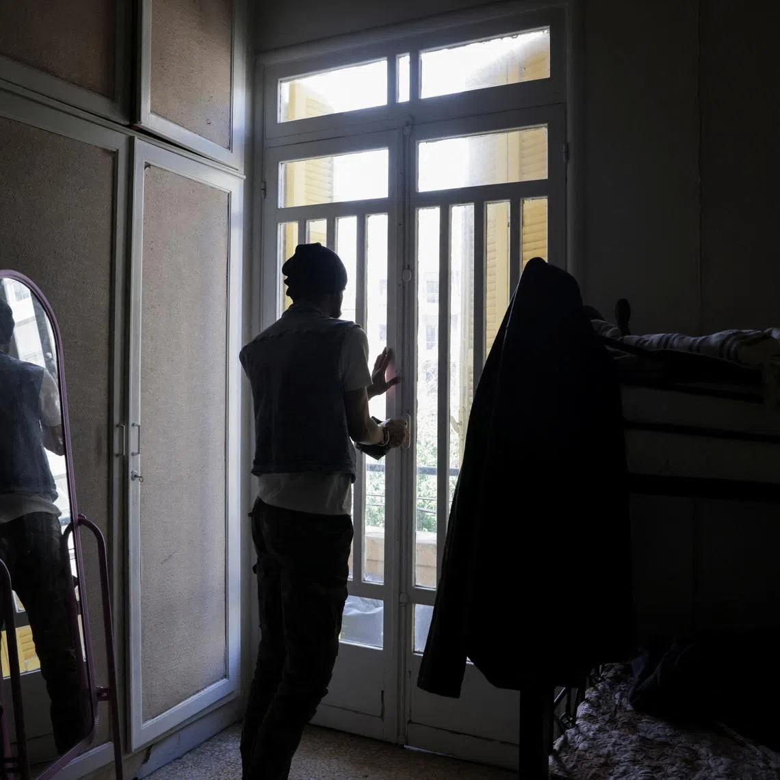 Mohammed, a gay man displaced from southern Lebanon, who spoke to Reuters on condition that his last name not be used, closes the door at a temporary shelter for displaced people in Beirut, Lebanon, May 4, 2026. REUTERS/Raghed Waked.