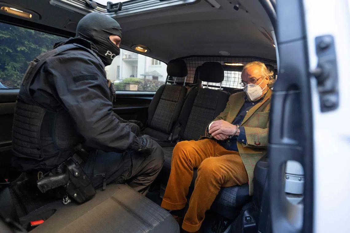 German special police forces detain Heinrich XIII Prinz Reuss (right), after searching a house in Frankfurt, on Dec 7, 2022.