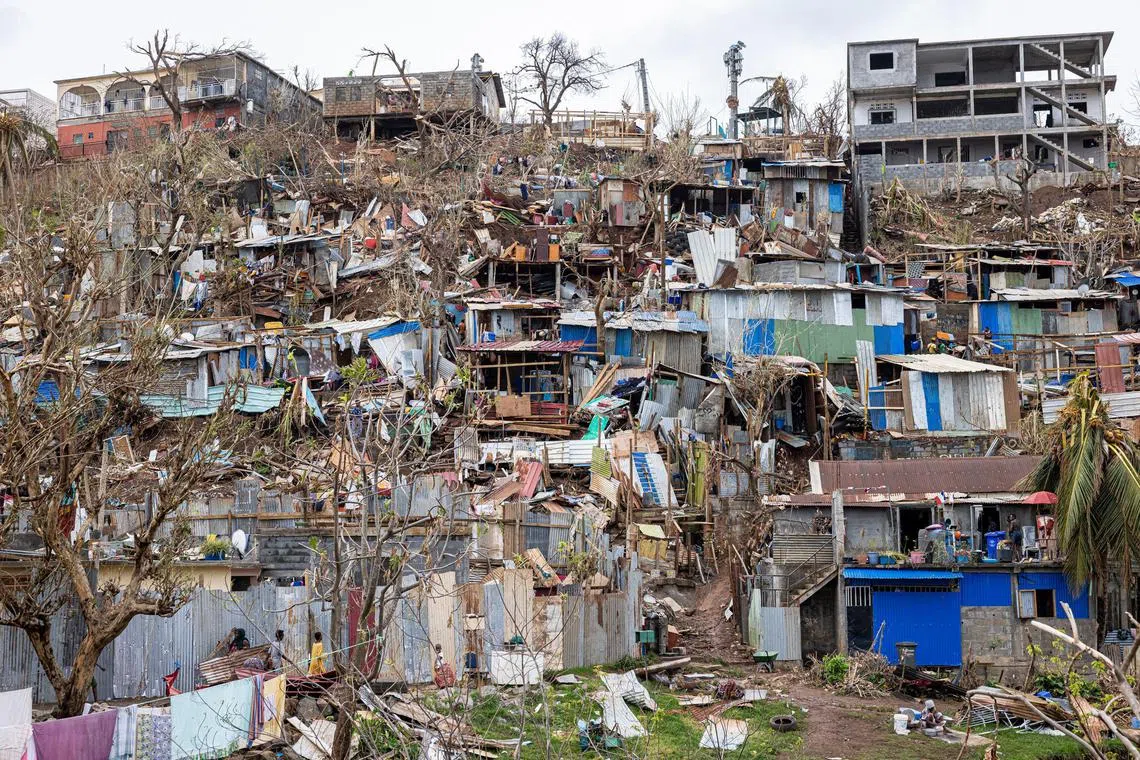 TOPSHOT - This photograph shows damaged homes in the city of Mamoudzou on the French Indian Ocean territory of Mayotte, after the cyclone Chido hit the archipelago on December 22, 2024. Paris declared "exceptional natural disaster" measures for Mayotte, France's poorest region near Madagascar off the coast of southeastern Africa. (Photo by PATRICK MEINHARDT / AFP)