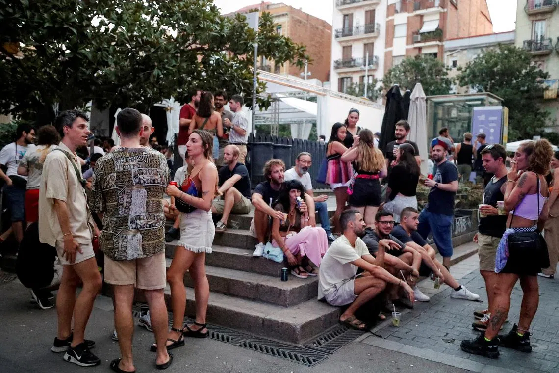 FILE PHOTO: Tourists and residents drink on a street in Gracia neighbourhood during a heatwave of the summer, in Barcelona, Spain August 19, 2023. REUTERS/Bruna Casas//File Photo