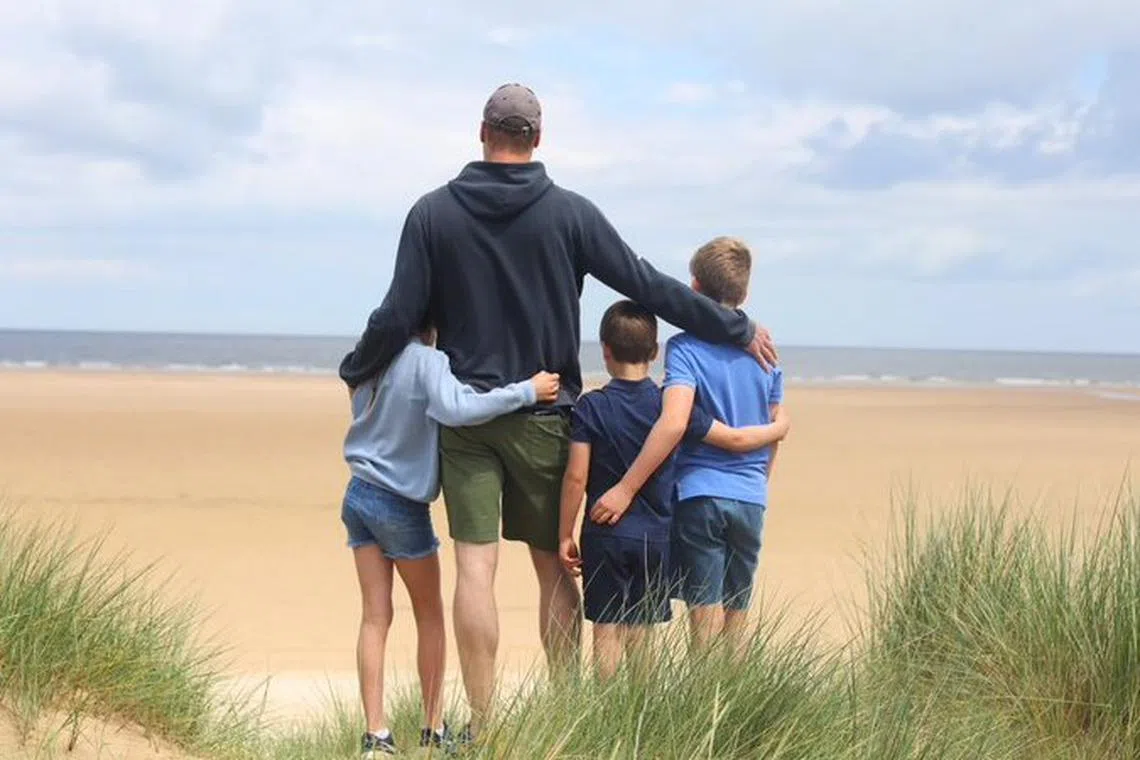 A photo taken by Princess Kate shows Prince George, 10, Princess Charlotte, 9, and Prince Louis, 6, hugging Prince William on a beach.