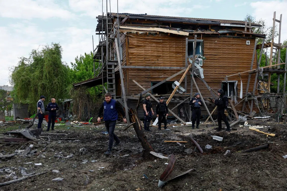 Police officers and war crimes prosecutors inspect a residential area hit by a Russian air strike, amid Russia's attack on Ukraine, in Kharkiv, Ukraine May 18, 2024. REUTERS/Valentyn Ogirenko