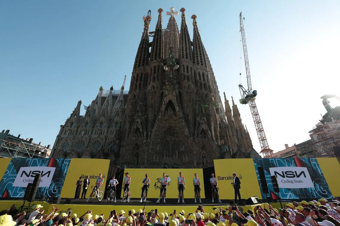 Cycling - Tour de France - Previews - Hospital Sant Pau, Barcelona, Spain - July 2, 2026  NSN Cycling Team's Jake Stewart, Biniam Girmay Hailu, Lewis Askey, Matis Louvel, Tom Van Asbroeck, Marco Frigo, George Bennett and Krists Neilands during the presentation as the Basilica of the Sagrada Familia is seen REUTERS/Gonzalo Fuentes