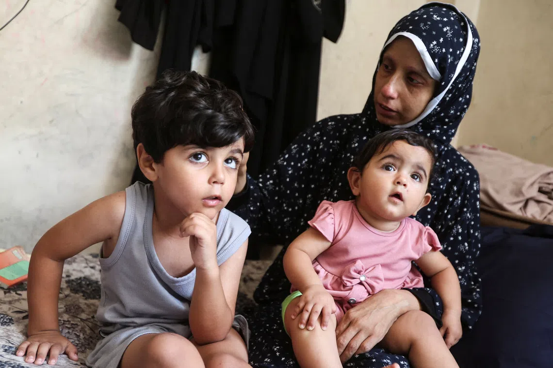 Displaced Palestinian cancer patient Khuloud Abu Sahmoud, 33, sitting with her children in an UNRWA school where she is sheltering in the southern Gaza Strip, on Aug 8.