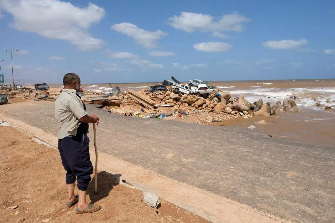 A man looking at the damaged cars, after a powerful storm and heavy rainfall hit Derna, Libya on Sept 12.