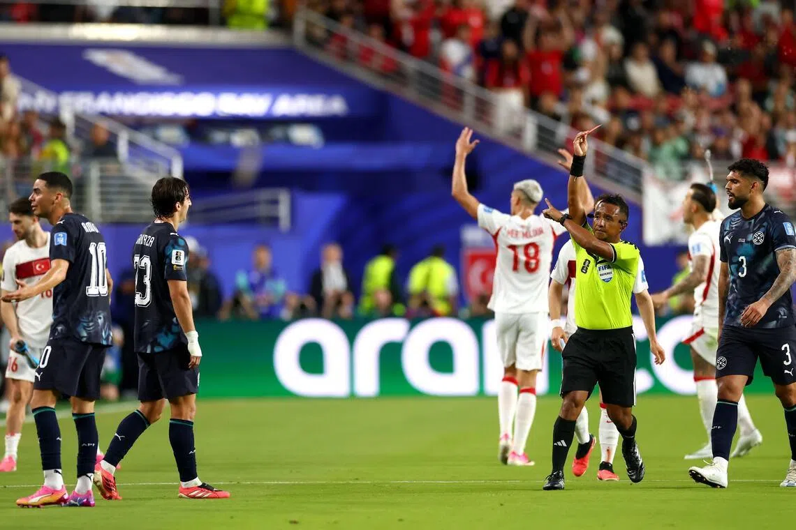 Paraguay’s Miguel Almiron was sent off for covering his mouth while speaking to Turkey’s Mert Muldur.
