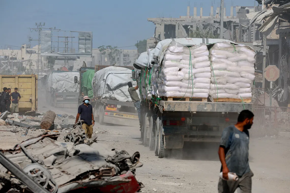 Trucks carry aid for Palestinians, amid a ceasefire between Israel and Hamas in Gaza, in Khan Younis, in the southern Gaza Strip, October 14, 2025. REUTERS/Ramadan Abed