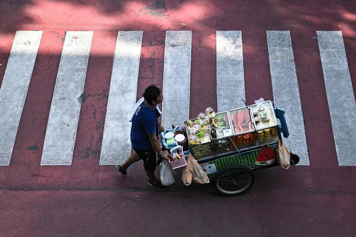 A street vendor pushes a cart of fresh fruit in Bangkok on April 30. 