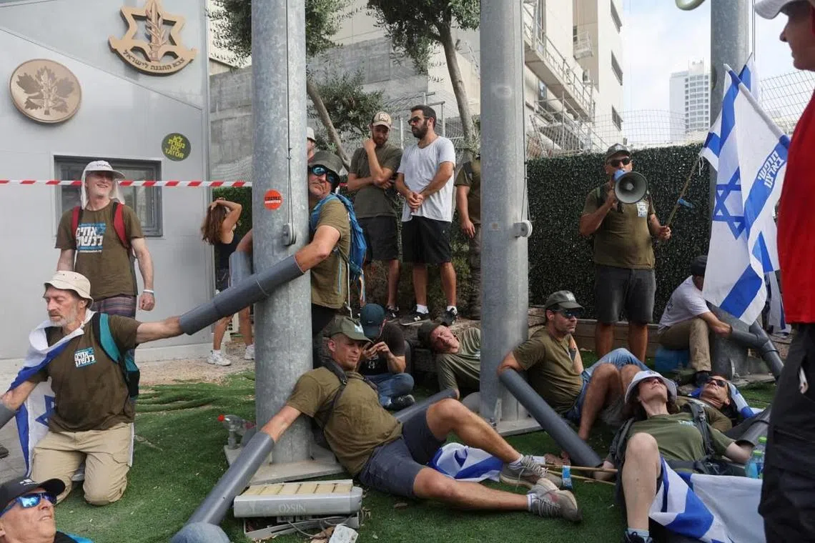 People who had chained themselves together protesting in front of the Ministry of Defence in Tel Aviv against Israeli Prime Minister Benjamin Netanyahu and his nationalist coalition government's judicial overhaul, on July 18, 2023.