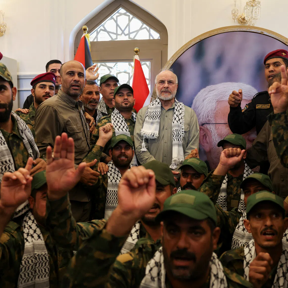 Iranian Parliament Speaker Mohammad Baqer Qalibaf stands with members of Iraq's Popular Mobilization Forces at the grave of Iraqi paramilitary commander Abu Mahdi al-Muhandis, who was killed alongside Iranian military commander Qassem Soleimani in a U.S. drone strike near Baghdad International Airport in January 2020, in Najaf, Iraq, August 21, 2026. REUTERS/Ahmed Saad