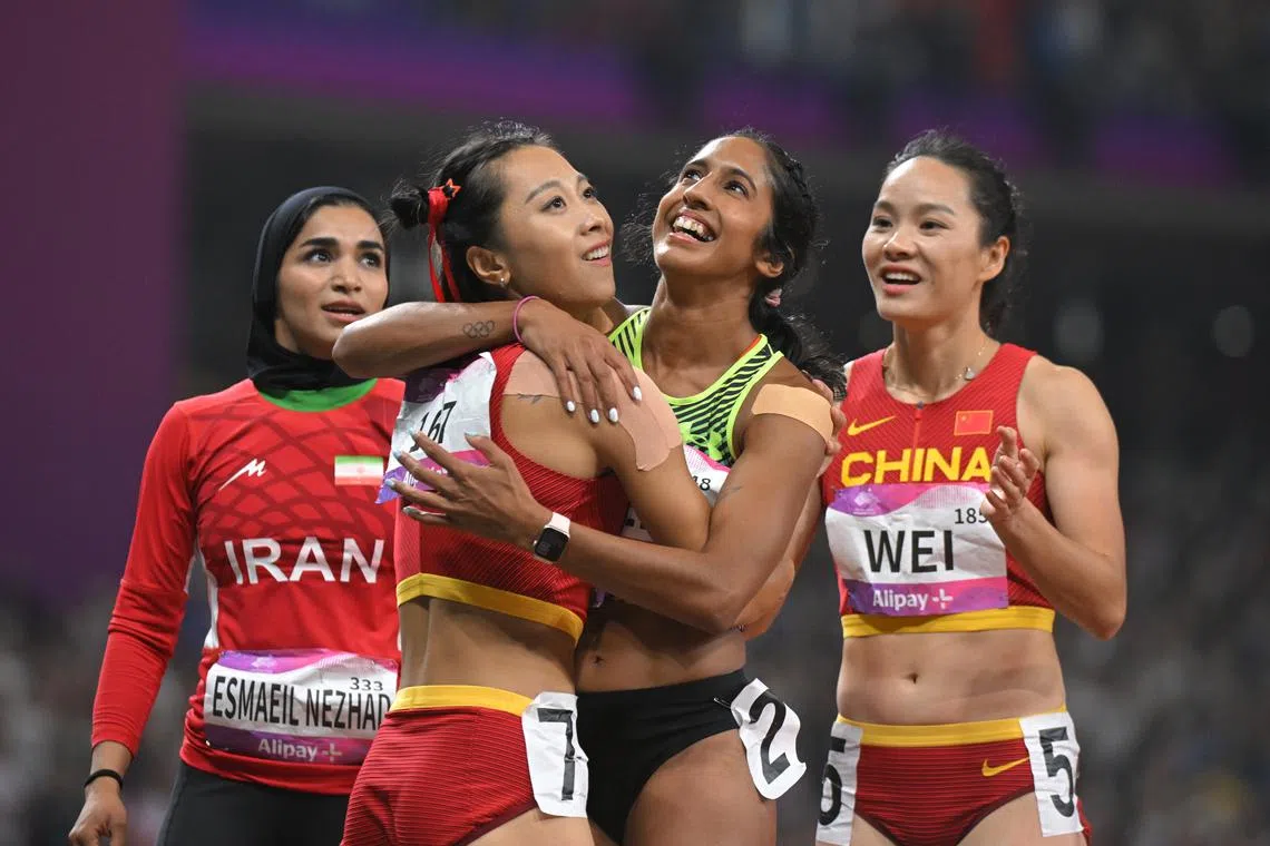 Shanti Pereira (centre) of Singapore hugging China’s Ge Manqi after the 19th Asian Games Athletics Women’s 100m final at the Hangzhou Olympic Sports Centre Stadium on Sept 30.