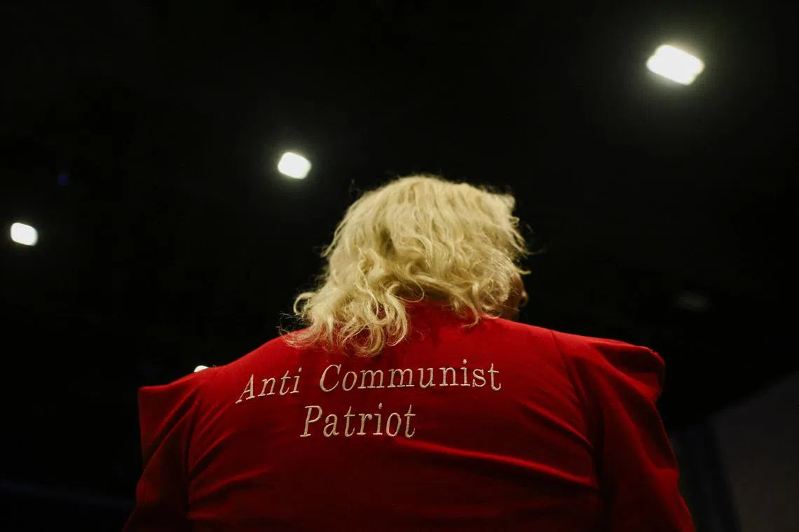 An attendee wears an outfit with \"Anti Communist Patriot\" written on it in Palm Beach County Convention Center, in West Palm Beach, Florida, U.S., November 5, 2024. REUTERS/Callaghan O'hare