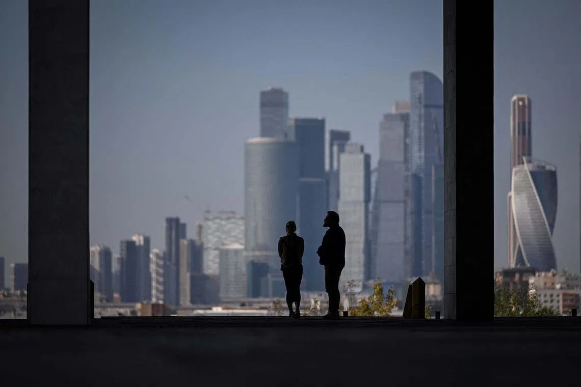 People stand at the observation point in front of skyscrapers of the Moscow International Business Centre (Moskva City) in Moscow on Sept 10.
