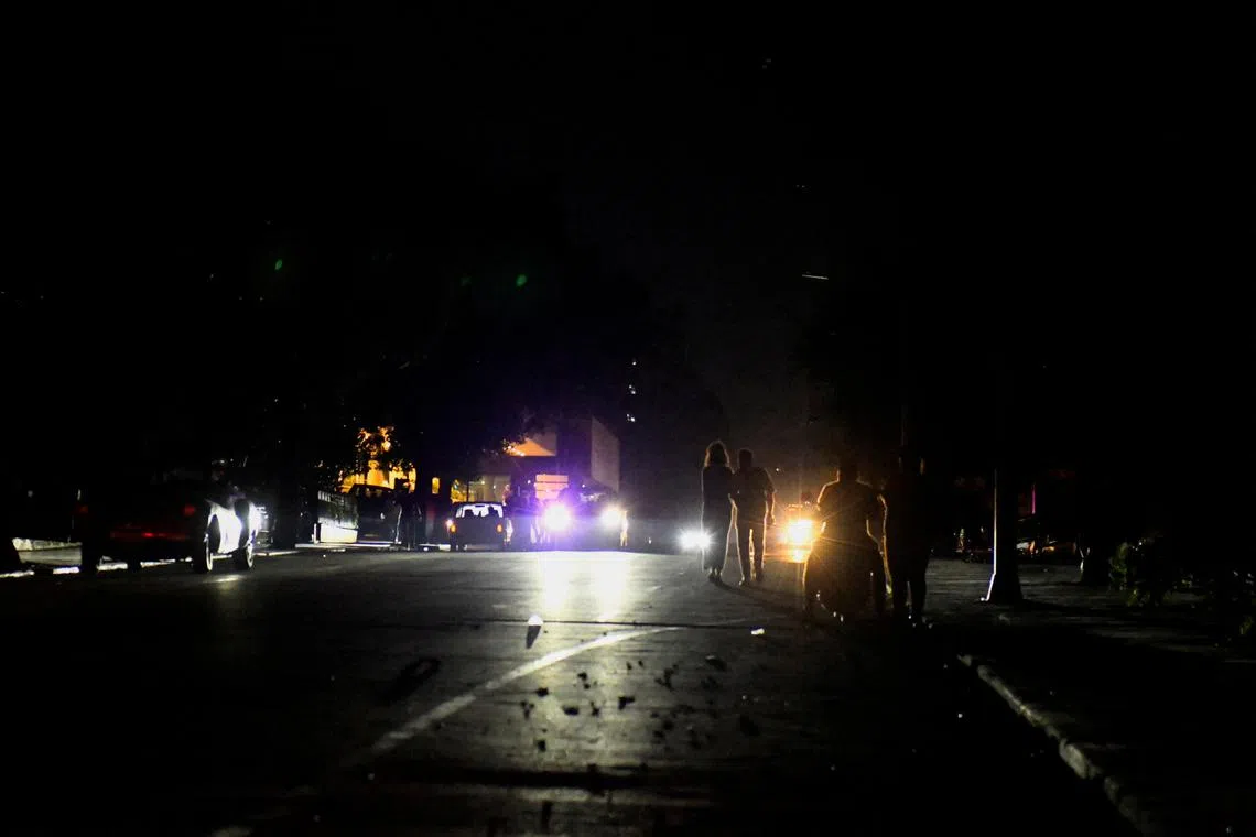 People walk on the street during a national electrical grid collapse, in Havana, Cuba, March 14, 2025. REUTERS/Norlys Perez