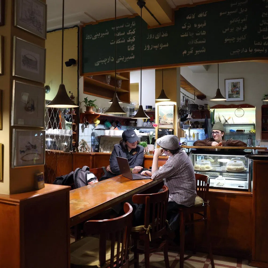 People sit inside a cafe in downtown Tehran, where they find a sliver of normalcy amid a war.
