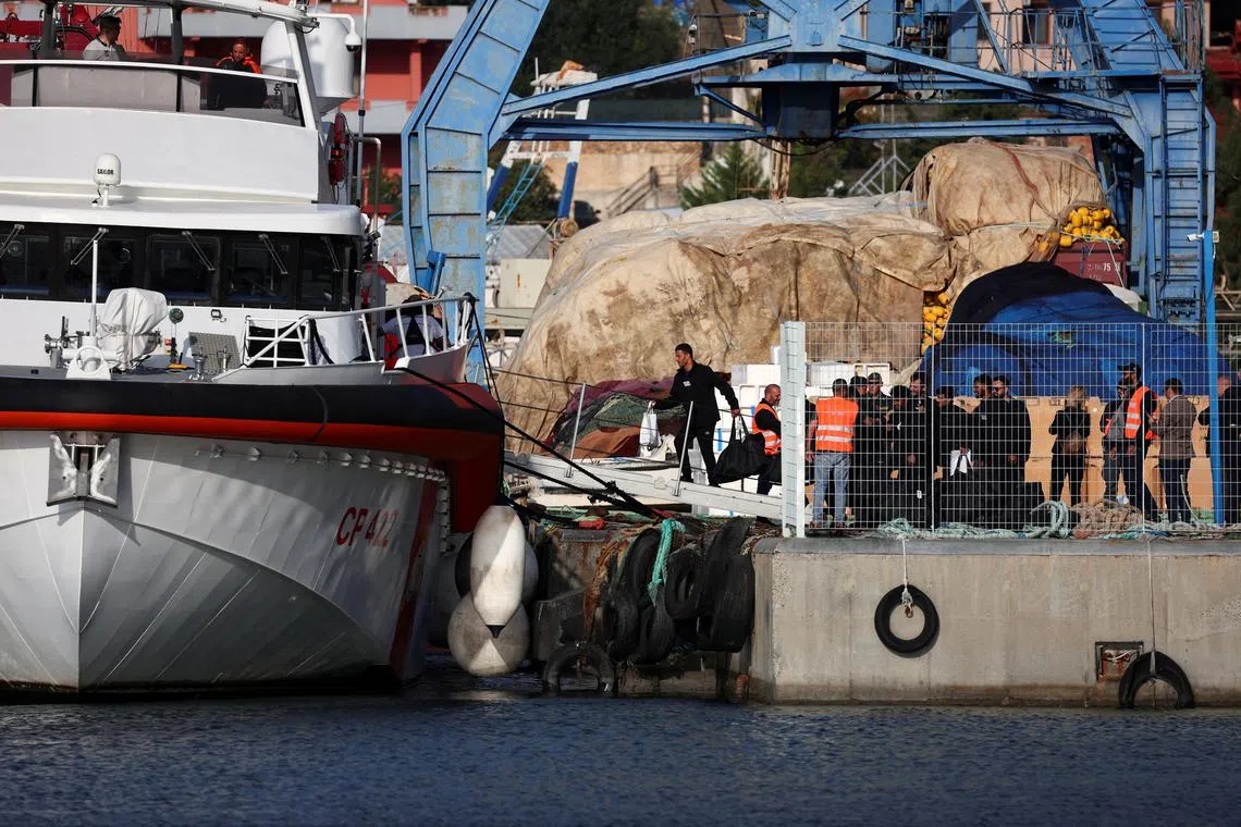 FILE PHOTO: Migrants, who were intercepted at sea and later detained at a reception facility in Albania, board an Italian coast guard vessel to leave for Italy after a court in Rome overturned their detention orders, in Shengjin, Albania, October 19, 2024. REUTERS/Florion Goga/File Photo