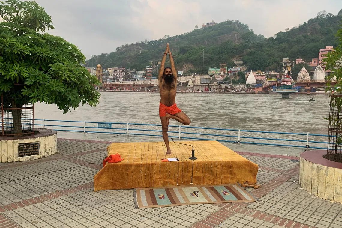FILE PHOTO: India's yoga guru Baba Ramdev performs yoga on the banks of the river Ganges ahead of International Yoga day, in the northern town of Haridwar, India, June 19, 2020. Picture taken June 19, 2020. REUTERS/Sunil Kataria/File Photo
